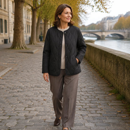 Woman wearing the Claire black quilted jacket on an autumn riverside walk — view 5
