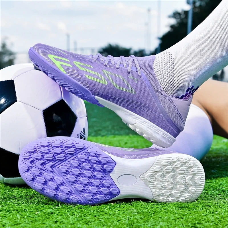Purple high top soccer cleats with non slip soles on a grassy field near ball — view 2