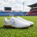 A model showcases professional short nail soccer cleats in dynamic front view, paired with sleek athletic outfit against