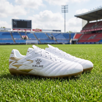 A model showcases professional short nail soccer cleats in dynamic front view, paired with sleek athletic outfit against