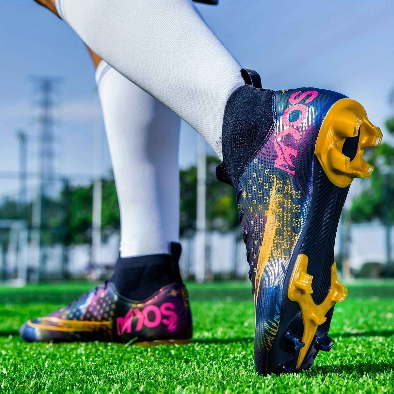 Colorful soccer cleats with a dynamic pattern and gold studs on grassy field — view 8 — view 8