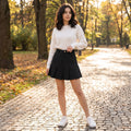 uniform skirt — A model showcases casual slim polyester mini skirt in navy blue, styled with fitted white top against neutral