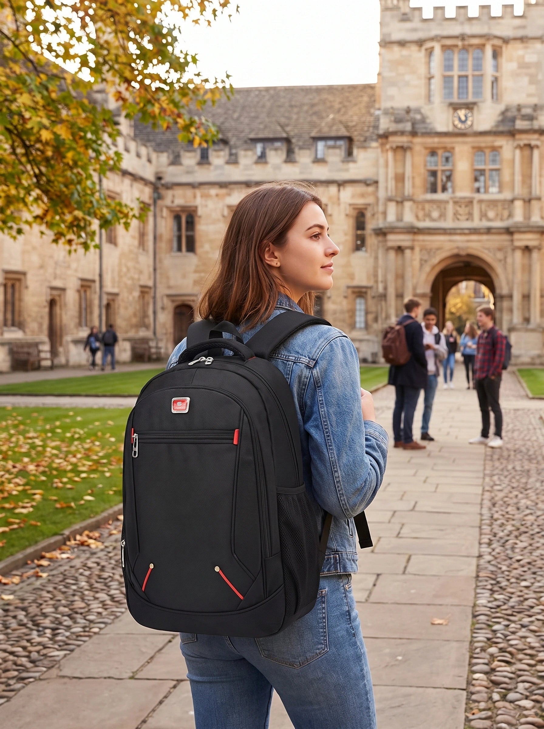 A model showcases the spacious Oxford University backpack in outfit showing dark jeans and light grey high waisted jacket