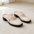 wedding guest shoes — Ivory cross strap backless Mary Jane pumps complete front view