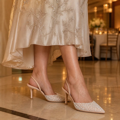wedding guest shoes — Mature woman wearing nude ivory pearl slingback shoes indoors — view 6