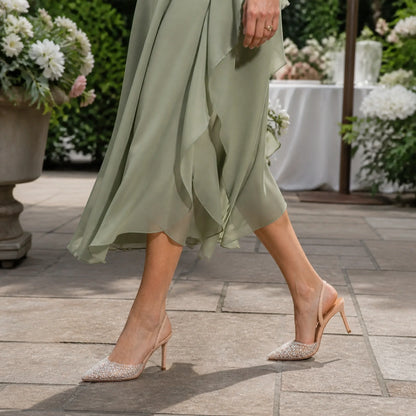 wedding guest shoes — Mature woman wearing nude ivory pearl slingback shoes outdoors — view 7