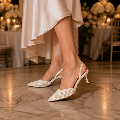 wedding guest shoes — Mature woman wearing ivory pearl slingback heels at an indoor reception — view 6